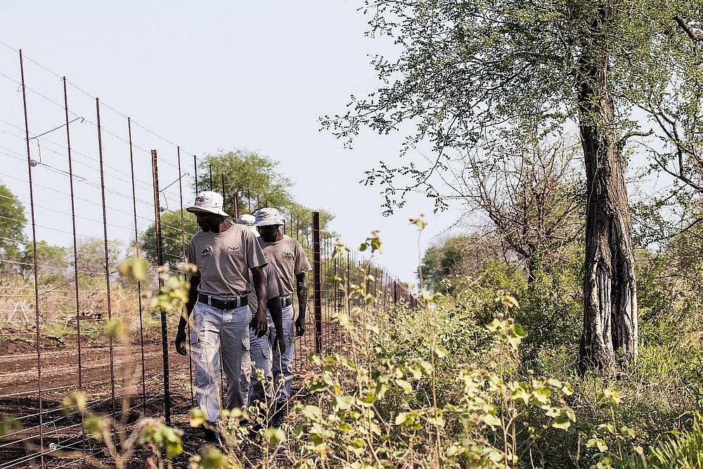 Village police in Mangalane patrol the fence.